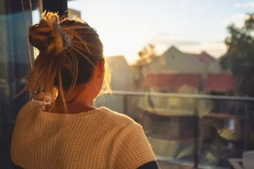 woman-looking-through-window-to-street.jpg